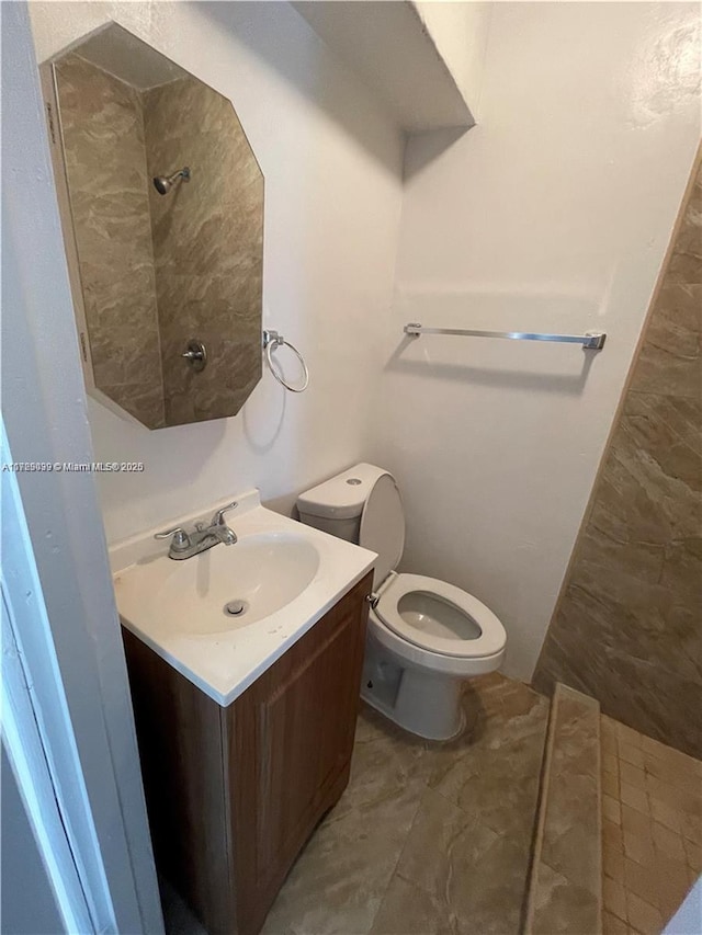 bathroom with a shower, toilet, and vanity