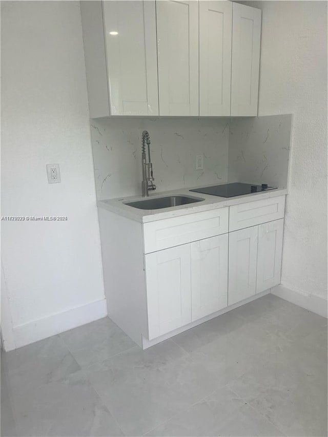 kitchen featuring sink, white cabinets, and black electric cooktop