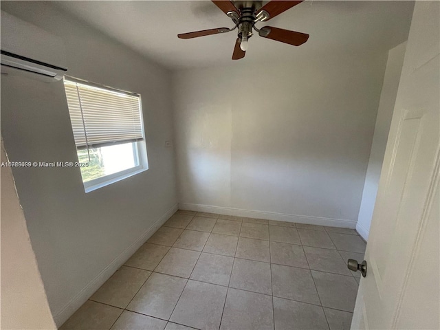 tiled spare room featuring an AC wall unit and ceiling fan