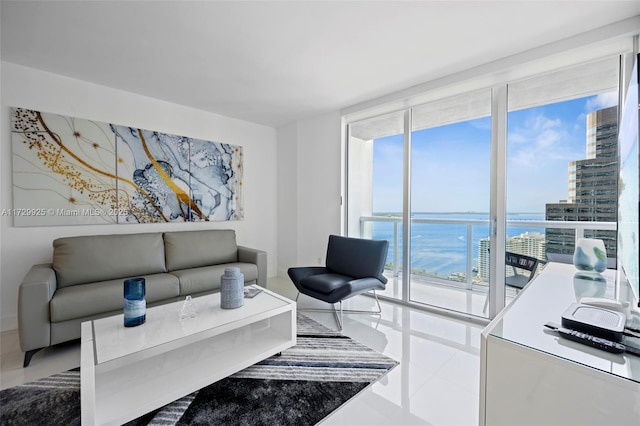 living room with a water view, tile patterned flooring, and expansive windows