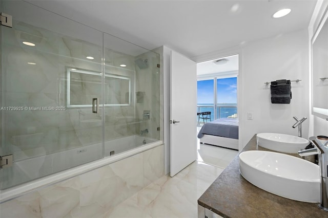 bathroom with sink, independent shower and bath, and a water view