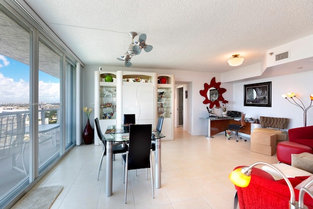 dining space with light tile patterned flooring and a textured ceiling