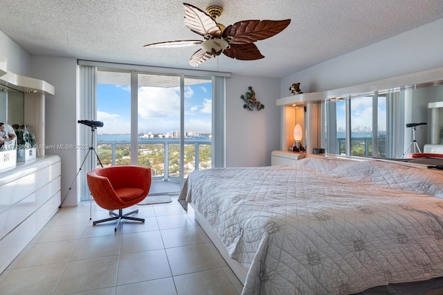 tiled bedroom with ceiling fan, a textured ceiling, and access to outside