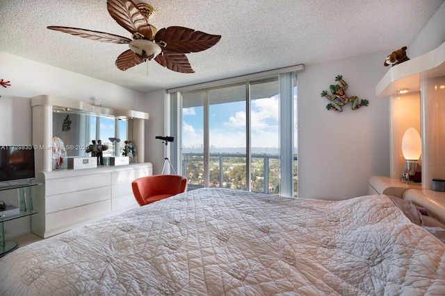 bedroom featuring ceiling fan, access to exterior, and a textured ceiling