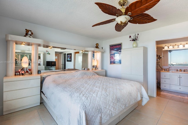 tiled bedroom featuring ceiling fan, sink, and a textured ceiling