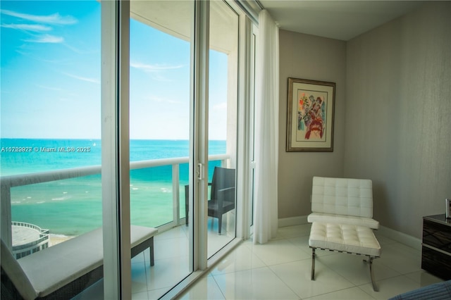 living area with a water view, light tile patterned floors, and a wealth of natural light