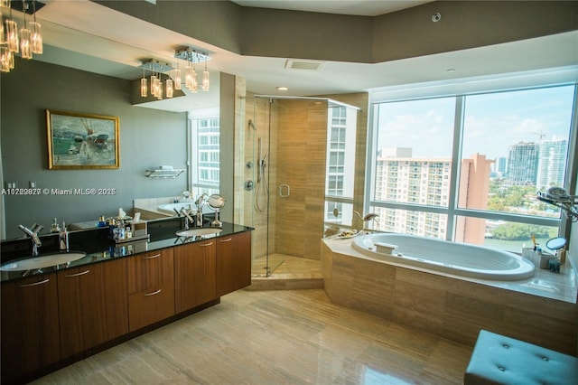 bathroom featuring vanity, shower with separate bathtub, and a healthy amount of sunlight