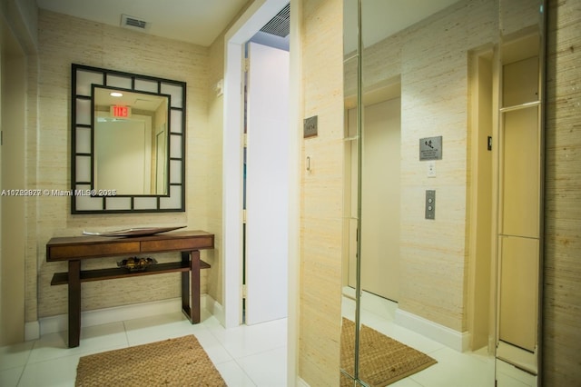 corridor with light tile patterned floors and elevator