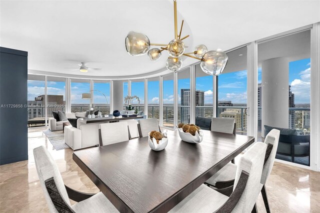 sunroom / solarium featuring ceiling fan with notable chandelier and a healthy amount of sunlight