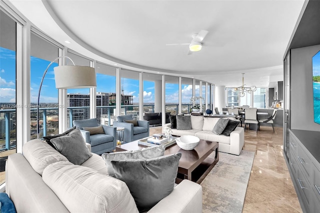 living room featuring expansive windows and ceiling fan with notable chandelier