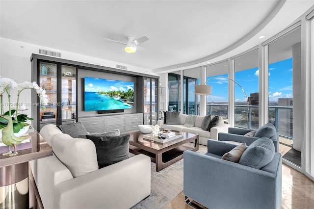 living room featuring ceiling fan and a wall of windows