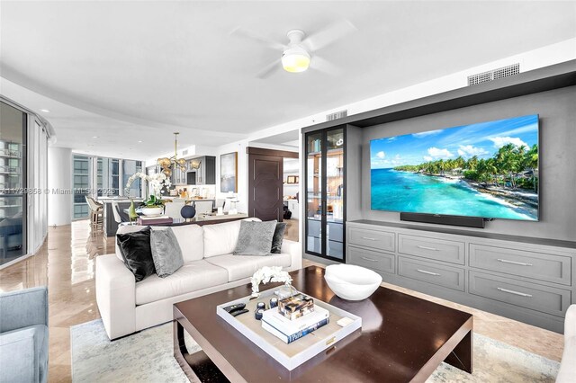 living room featuring ceiling fan with notable chandelier