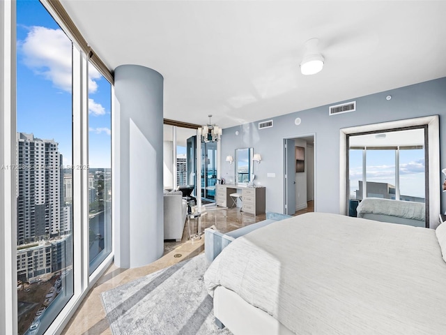 bedroom with floor to ceiling windows and a chandelier