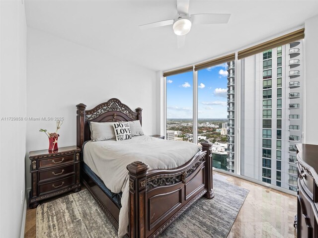 bedroom featuring access to outside, floor to ceiling windows, and ceiling fan