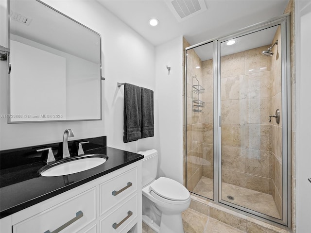 bathroom featuring vanity, an enclosed shower, and toilet