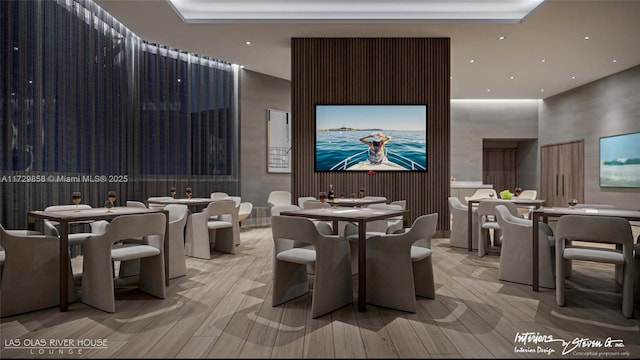 dining room featuring a towering ceiling and light wood-type flooring