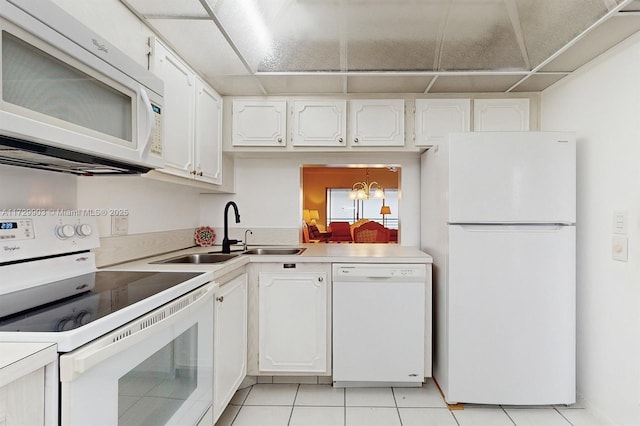 1501 S Ocean Blvd Unit 301, Lauderdale By The Sea, FL 33062 - kitchen with white appliances, a sink, light tile patterned flooring, white cabinets, and a chandelier