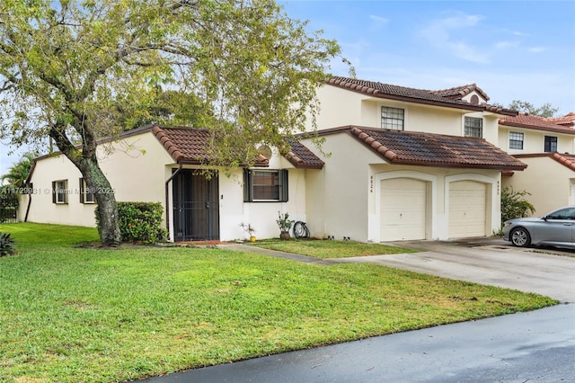 mediterranean / spanish-style home featuring a garage and a front yard