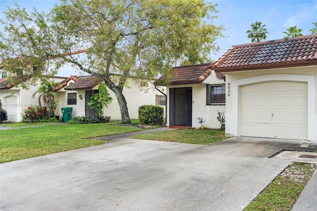 mediterranean / spanish house featuring a garage and a front lawn