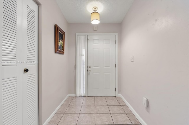 entryway with light tile patterned floors and a textured ceiling