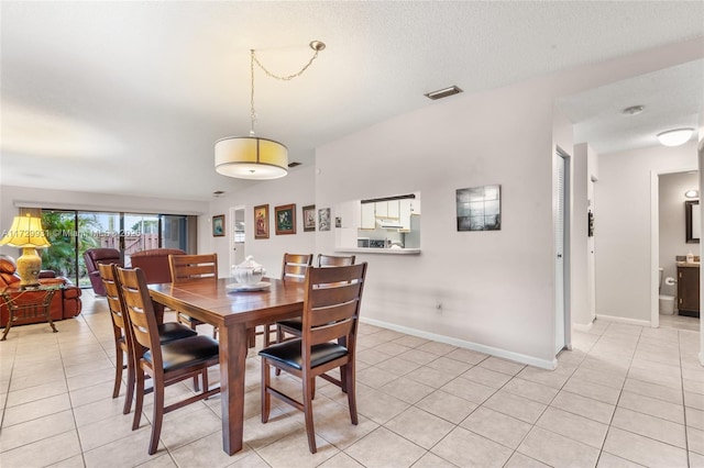 dining room with light tile patterned floors and a textured ceiling