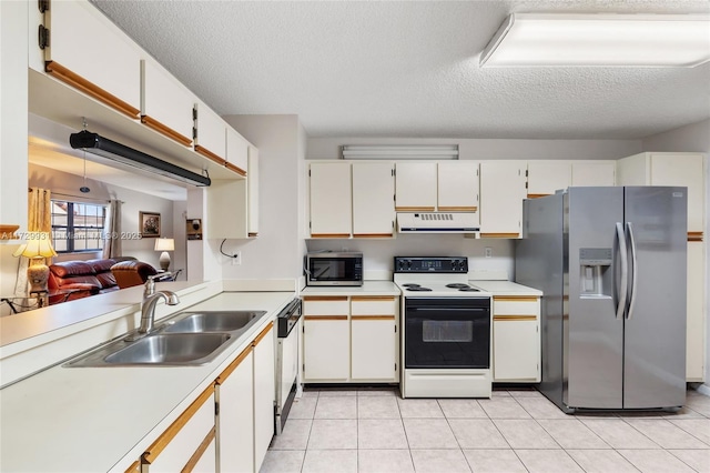 kitchen featuring a textured ceiling, appliances with stainless steel finishes, white cabinetry, sink, and light tile patterned flooring