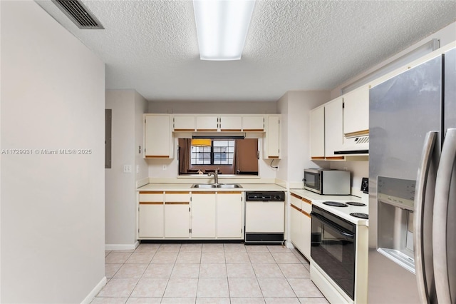 kitchen featuring sink, white cabinets, light tile patterned floors, and appliances with stainless steel finishes