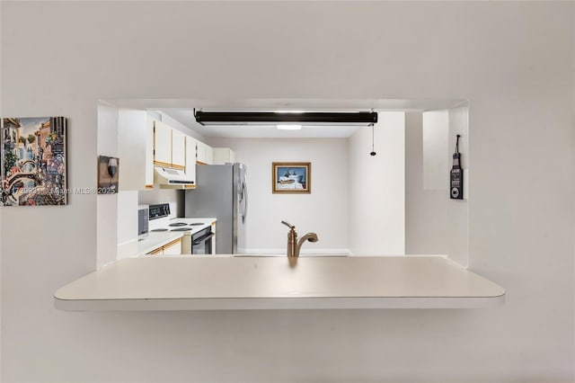 kitchen with white cabinetry, stainless steel fridge, kitchen peninsula, and range with electric cooktop