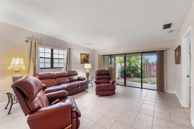 living room featuring a textured ceiling and light tile patterned floors