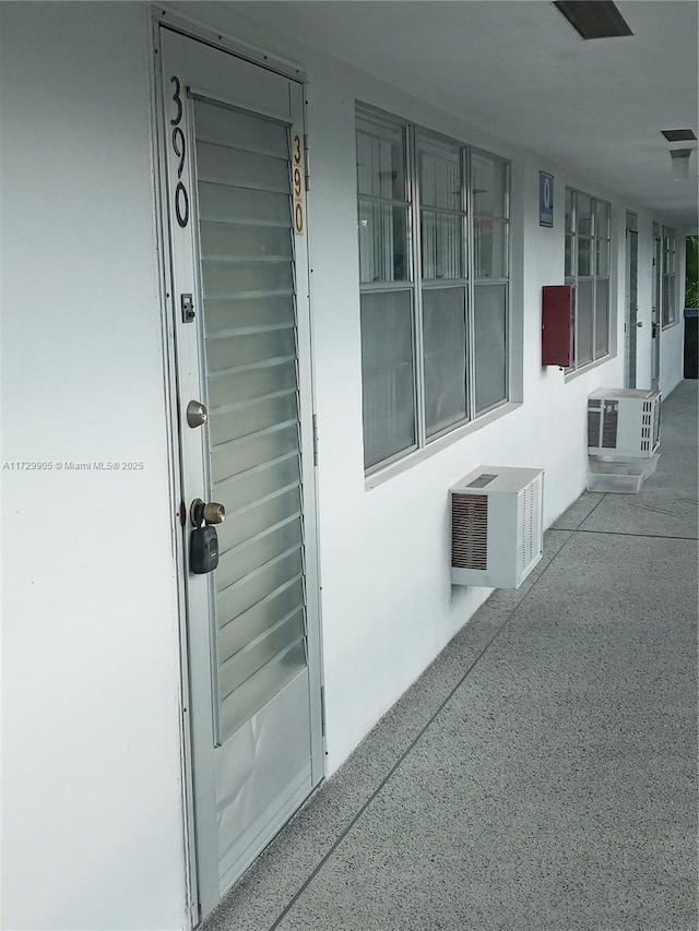 view of exterior entry with an AC wall unit