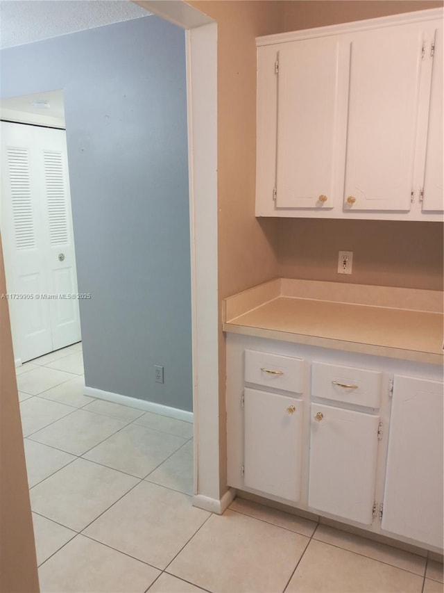 kitchen featuring white cabinets and light tile patterned flooring