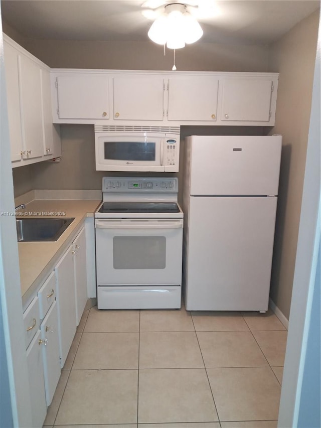 kitchen featuring light tile patterned floors, sink, white appliances, and white cabinets