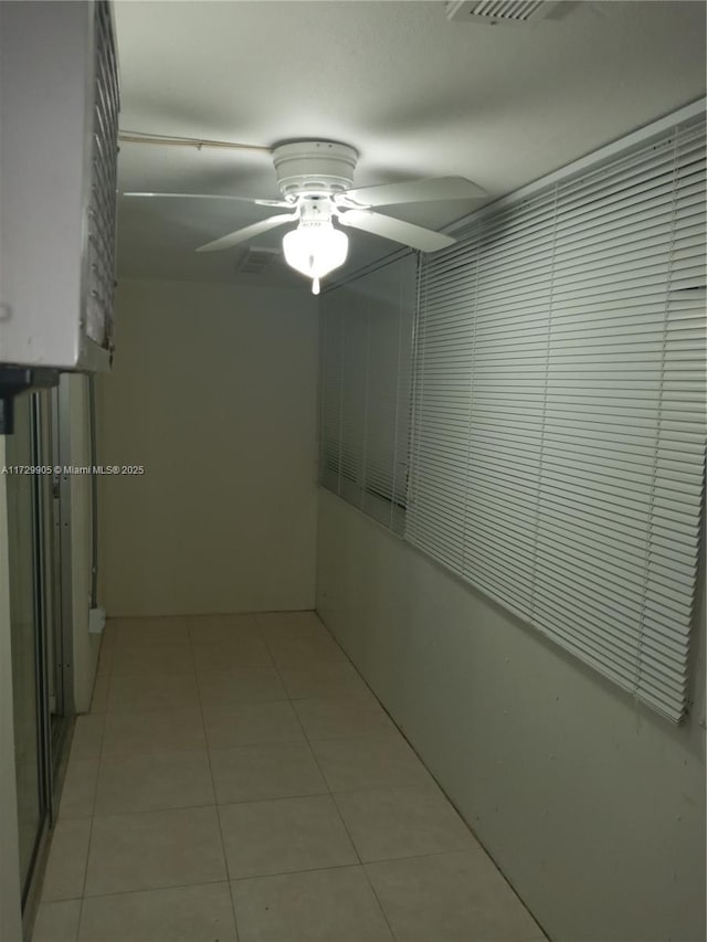 tiled empty room featuring ceiling fan