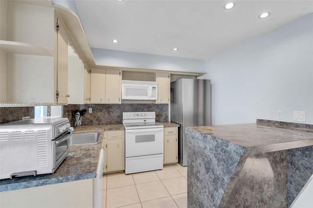 kitchen featuring white appliances, light tile patterned floors, decorative backsplash, cream cabinetry, and sink