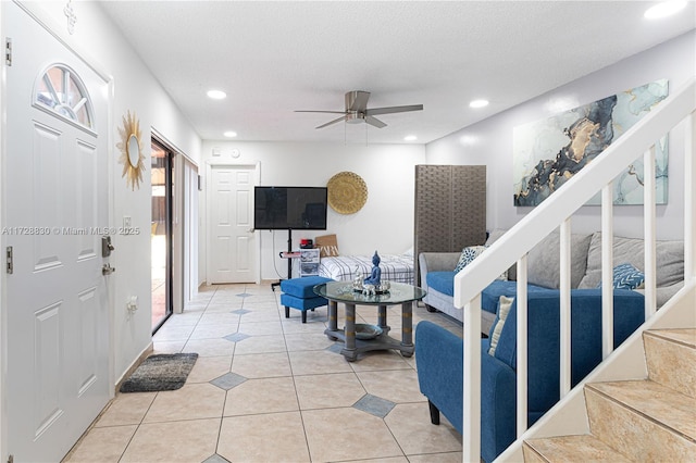 living room featuring ceiling fan, a textured ceiling, and tile patterned flooring