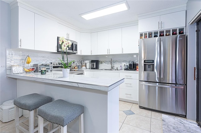 kitchen featuring white cabinetry, sink, kitchen peninsula, a breakfast bar, and stainless steel appliances