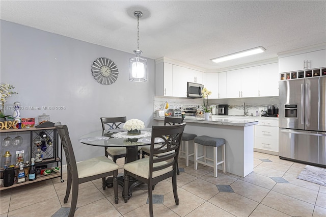 kitchen featuring kitchen peninsula, white cabinets, a breakfast bar area, and stainless steel appliances