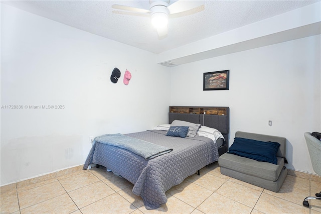 tiled bedroom with a textured ceiling and ceiling fan