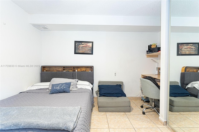 bedroom featuring a textured ceiling and tile patterned floors