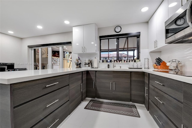 kitchen with dark brown cabinets, sink, white cabinetry, black electric stovetop, and decorative backsplash