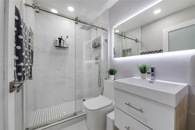 bathroom featuring toilet, a shower with shower door, and vanity