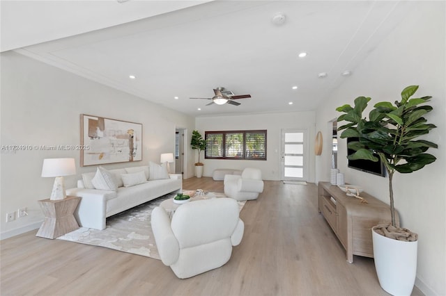 living room featuring crown molding, ceiling fan, and light hardwood / wood-style floors