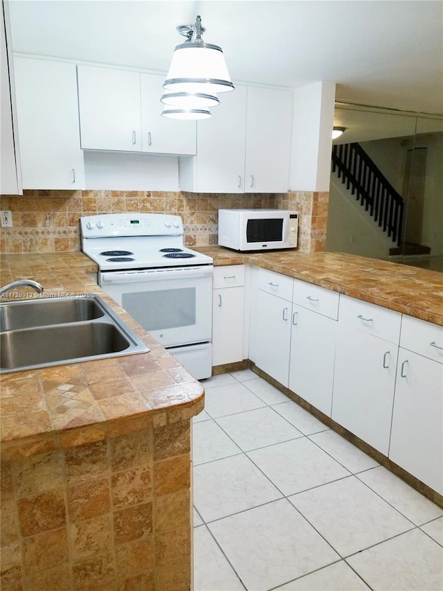 kitchen featuring sink, white appliances, white cabinetry, tasteful backsplash, and decorative light fixtures