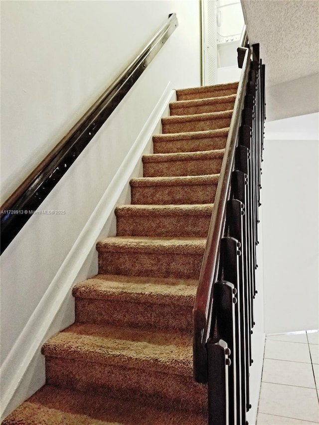 stairs featuring tile patterned flooring and a textured ceiling