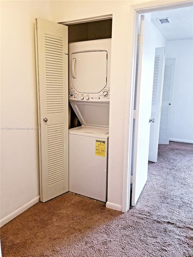 laundry room with stacked washer and clothes dryer and carpet flooring