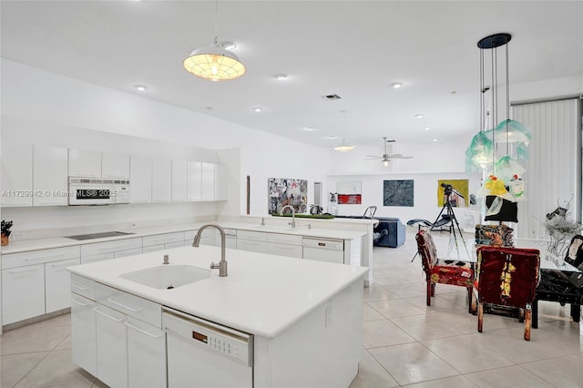 kitchen with sink, white appliances, a center island with sink, and pendant lighting