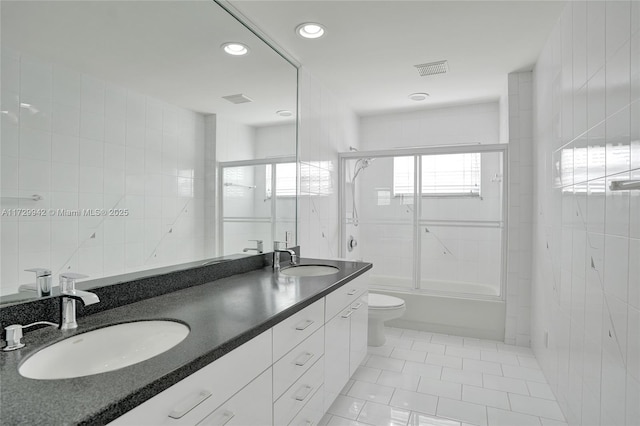 full bathroom with tile patterned floors, toilet, enclosed tub / shower combo, and tile walls