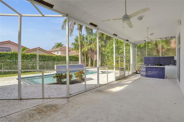 unfurnished sunroom with ceiling fan