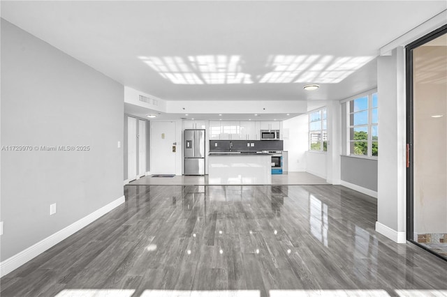 unfurnished living room with sink and dark hardwood / wood-style flooring