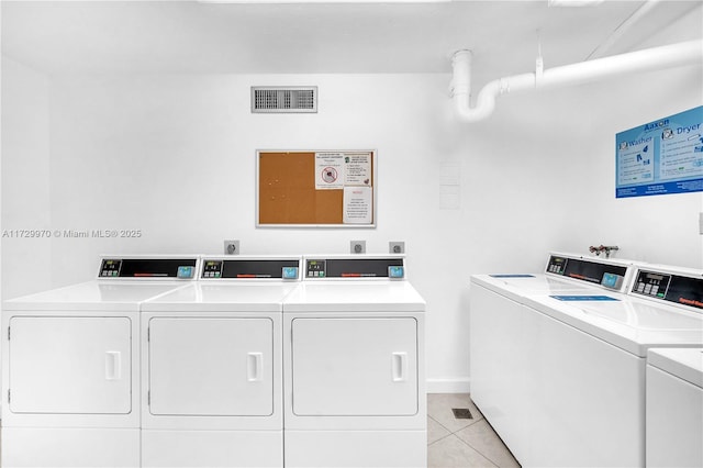 clothes washing area with light tile patterned floors and independent washer and dryer